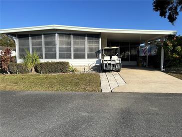 Mobile home with carport and golf cart at 101 Mango Cv, Leesburg, FL 34748