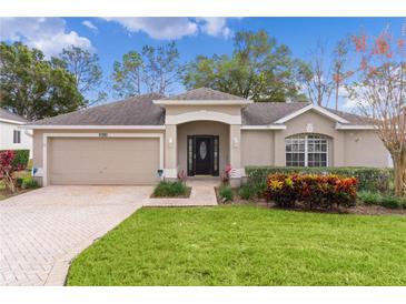 Single-story house with a two-car garage and well-manicured lawn at 3614 Kingswood Ct, Clermont, FL 34711