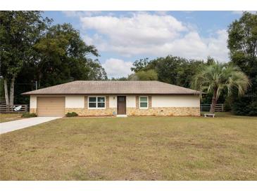 Ranch-style home with a large yard and single car garage at 4566 County Road 116, Wildwood, FL 34785