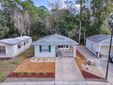 Single-story home with carport and landscaped yard at 32314 Oak Park Dr, Leesburg, FL 34748