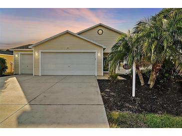 Inviting exterior with a two-car garage and landscaped yard at 3810 Cosmos Way, The Villages, FL 32163