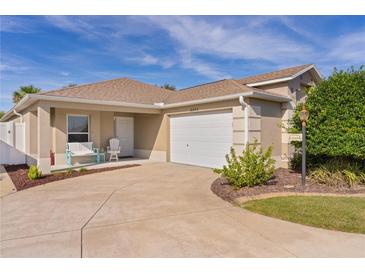 Single-story home with a two-car garage and landscaped yard at 2243 Montbrook Pl, The Villages, FL 32162