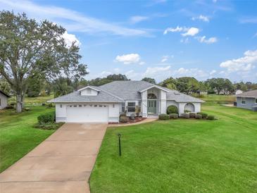 Single-story home with a two-car garage and well-manicured lawn at 5126 County Road 125, Wildwood, FL 34785