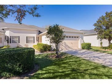 Well-maintained house with a two-car garage and lush lawn at 1018 Green Gate Blvd, Groveland, FL 34736