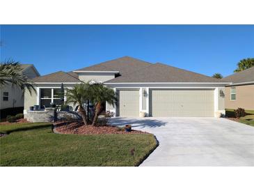 Two-story house with two-car garage and landscaped yard at 1881 Sassparilla Way, The Villages, FL 32162