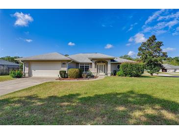 One-story home with attached garage, landscaping, and a spacious lawn at 3290 Se 53Rd Ct, Ocala, FL 34480