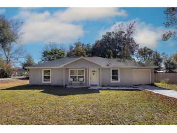 Newly constructed home with gray exterior, driveway, and well-maintained lawn at 1658 Ne 162Nd Pl, Citra, FL 32113