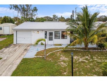 Cute one-story home with attached garage and palm trees at 404 Thomas Ave, Frostproof, FL 33843