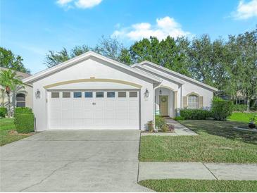 One-story home with white exterior, two-car garage, and landscaped lawn at 341 Lake Suzanne Dr, Lake Wales, FL 33859
