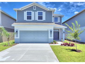 Two-story house with gray siding, white trim, and a two-car garage at 1413 Leamington Ln, Winter Haven, FL 33884