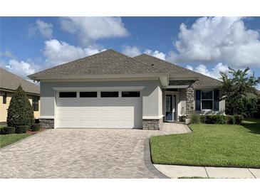 Single-story home with a two-car garage, stone accents, and a paved driveway at 7779 Lake James Blvd, Lakeland, FL 33810