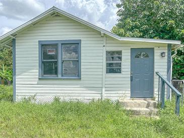 White house with gray door and overgrown grass at 1133 N Swindell Ave, Lakeland, FL 33805