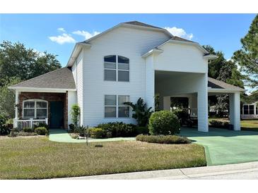 Two-story home with covered carport and landscaping at 1214 Motorcoach Dr, Polk City, FL 33868