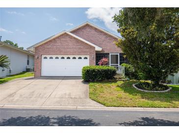 Brick ranch home with a two-car garage and landscaping at 6118 Silver Lakes W Dr, Lakeland, FL 33810