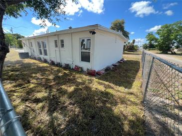 White house exterior with a yard and chain link fence at 143 D St, Lake Wales, FL 33853