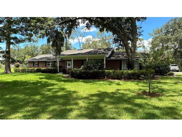 Brick ranch house with covered porch and large yard at 7520 Kathleen Rd, Lakeland, FL 33810