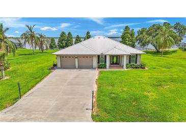 Single-story home with two-car garage and waterfront view at 7884 N Lake Buffum Shores Rd, Fort Meade, FL 33841