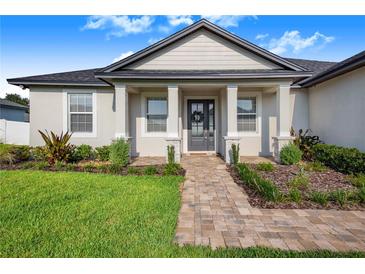 One-story home with gray roof, light beige walls, and a walkway leading to the front door at 5017 Ridgefield Lane, Lakeland, FL 33812