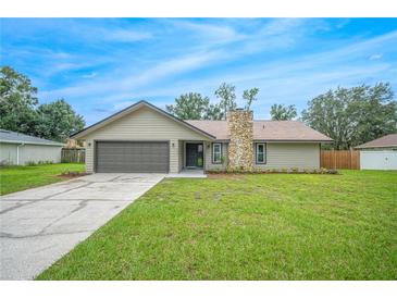 Newly renovated house with a stone chimney and a spacious lawn at 4500 Old Colony Rd, Mulberry, FL 33860