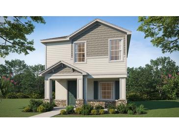 Two-story house with gray and beige siding, green door, and stone accents at 265 Crossings Ave, St Cloud, FL 34771