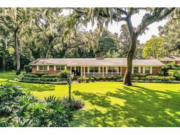 Ranch home showcasing a spacious lawn and lush landscaping at 7525 Catherine Dr, Lakeland, FL 33810