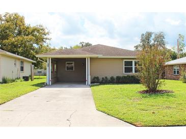 Tan single-story house with carport and well maintained lawn at 608 Lark Dr, Lakeland, FL 33813