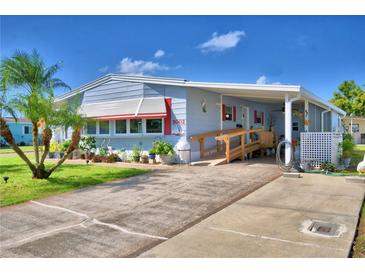 Cute Florida mobile home with carport, ramp, and landscaped yard at 5002 Lodgewood Dr, Lakeland, FL 33810