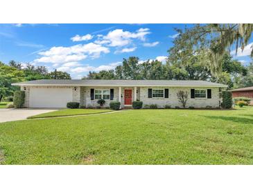 Ranch-style home with brick facade, attached garage, and spacious lawn at 1175 E George St, Bartow, FL 33830
