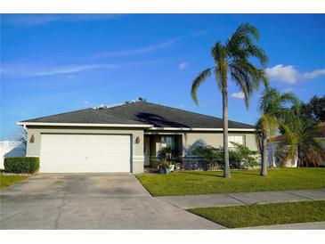 Single-story home with attached garage, palm trees, and manicured lawn at 1015 Highland Crest Cir, Lake Wales, FL 33853