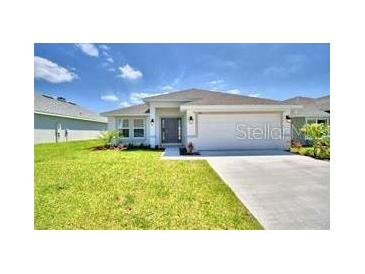One-story home with a two-car garage and landscaped lawn at 1564 Leamington Ln, Winter Haven, FL 33884