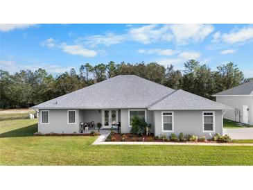 Single-story house with a grey exterior and landscaped yard at 4510 Roundup Dr, Polk City, FL 33868