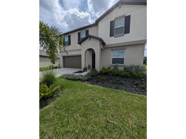 Two-story house with a neutral color scheme, landscaping, and a two-car garage at 2739 Red Egret Dr, Bartow, FL 33830