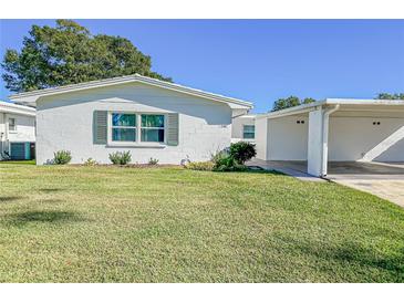 White single story home with carport and green lawn at 718 Barber Cir # 718, Lakeland, FL 33803