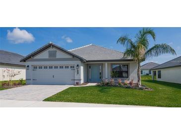 One-story home with gray siding, light gray roof, and a two-car garage at 5114 Villa Crest Way, Auburndale, FL 33823