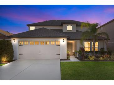 Two-story house with a two-car garage, landscaped lawn, and neutral color palette at 2199 Ontario Way, Lakeland, FL 33805
