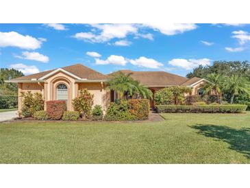 Single-story home with a manicured lawn and lush landscaping at 3206 Heron Cv, Winter Haven, FL 33884