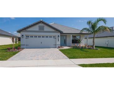 One-story home with gray siding, light gray garage door, and landscaped yard at 4437 Juliana Lake Dr, Auburndale, FL 33823