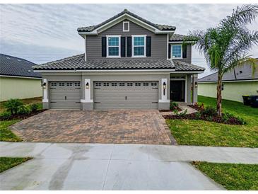 Two-story house with gray siding, tile roof, and a two-car garage at 4443 Juliana Lake Dr, Auburndale, FL 33823