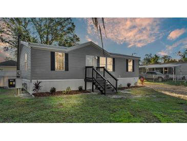 Gray manufactured home with landscaping and steps leading to the entrance at 4626 Dail Rd, Lakeland, FL 33813