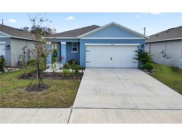 Charming blue two-story home with a white garage door and landscaped front yard at 1754 Eagle Hammock Blvd, Eagle Lake, FL 33839