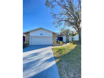 House exterior featuring a two-car garage and well-maintained lawn at 3709 Feather Dr, Lakeland, FL 33812