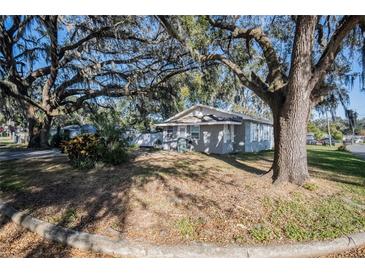Gray house with mature trees and a spacious front yard at 806 Lafayette Ln, Lakeland, FL 33805
