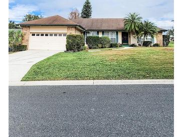 Single-story house with attached garage, landscaping, and a palm tree at 5805 Danterbury Ct, Lakeland, FL 33810
