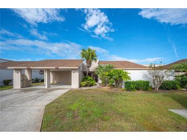 Tan house with carport and landscaped yard at 4243 Oak Loop # 35, Mulberry, FL 33860