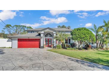 Beautiful home with red garage door, landscaping, and paved driveway at 809 Fairlane Dr, Lakeland, FL 33809