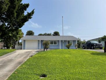 House exterior showcasing light blue siding, a neat lawn, and a driveway at 4513 Saxon Dr, New Smyrna Beach, FL 32169