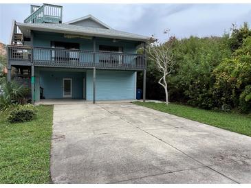 Two-story home with blue siding and spacious driveway at 6468 Engram Rd, New Smyrna Beach, FL 32169