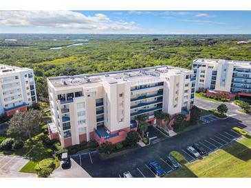 Aerial view of a condo building with lush landscaping and water views at 5300 S Atlantic Ave # 6-505, New Smyrna Beach, FL 32169