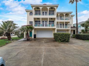 Three-story house with double garage and arched balconies at 610 S Atlantic Ave, New Smyrna Beach, FL 32169