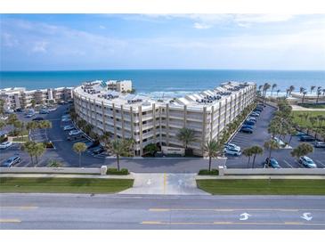 Oceanfront condo building with ample parking and tropical landscaping at 4501 S Atlantic Ave # 1210, New Smyrna Beach, FL 32169